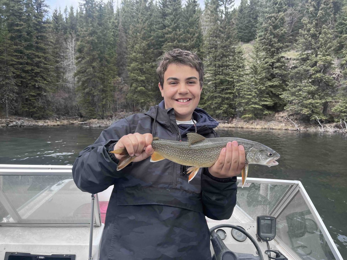 A freshly caught trout held over the water at Rock Lake