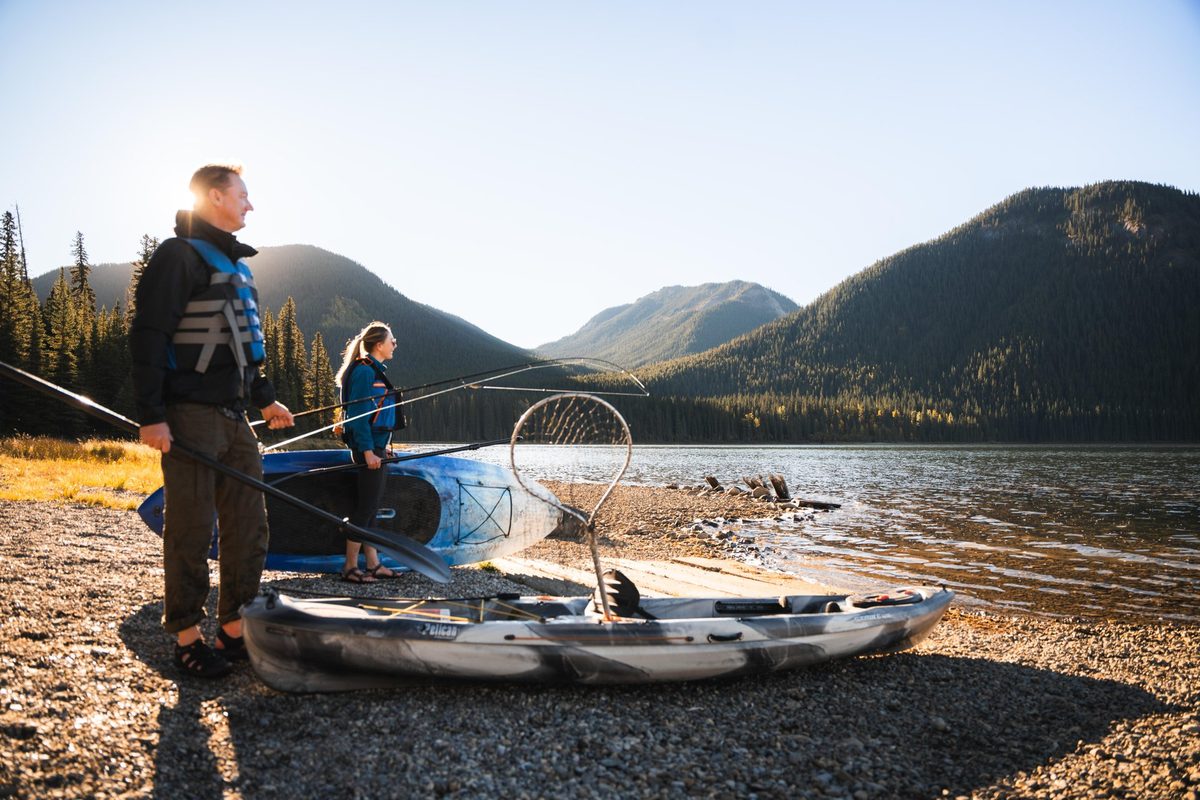 A family paddling a canoe across Rock Lake beneath forested slopes