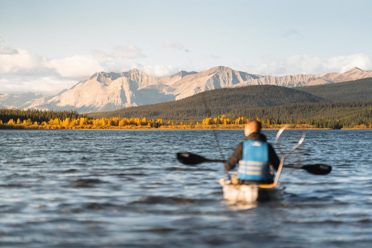 Paddling on the calm water of Rock Lake beneath the mountains