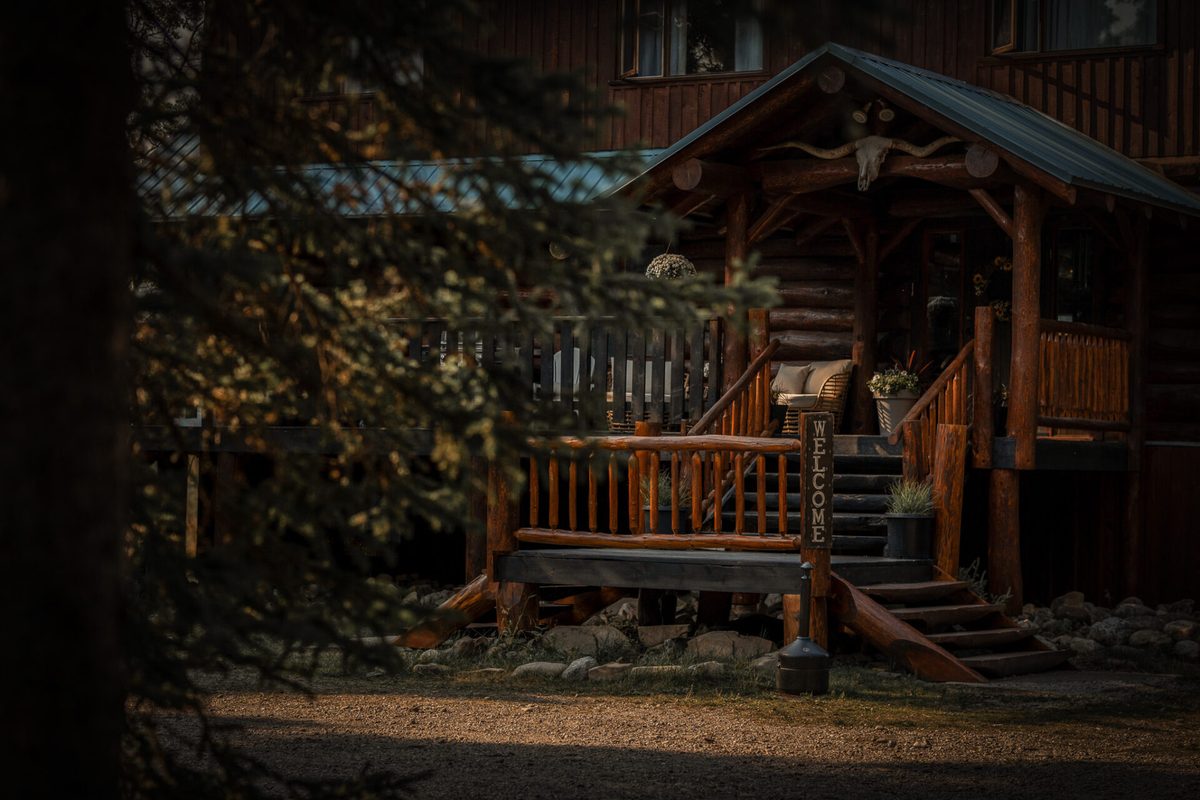 Golden evening light on the log entrance of Rock Lake Earth Lodge