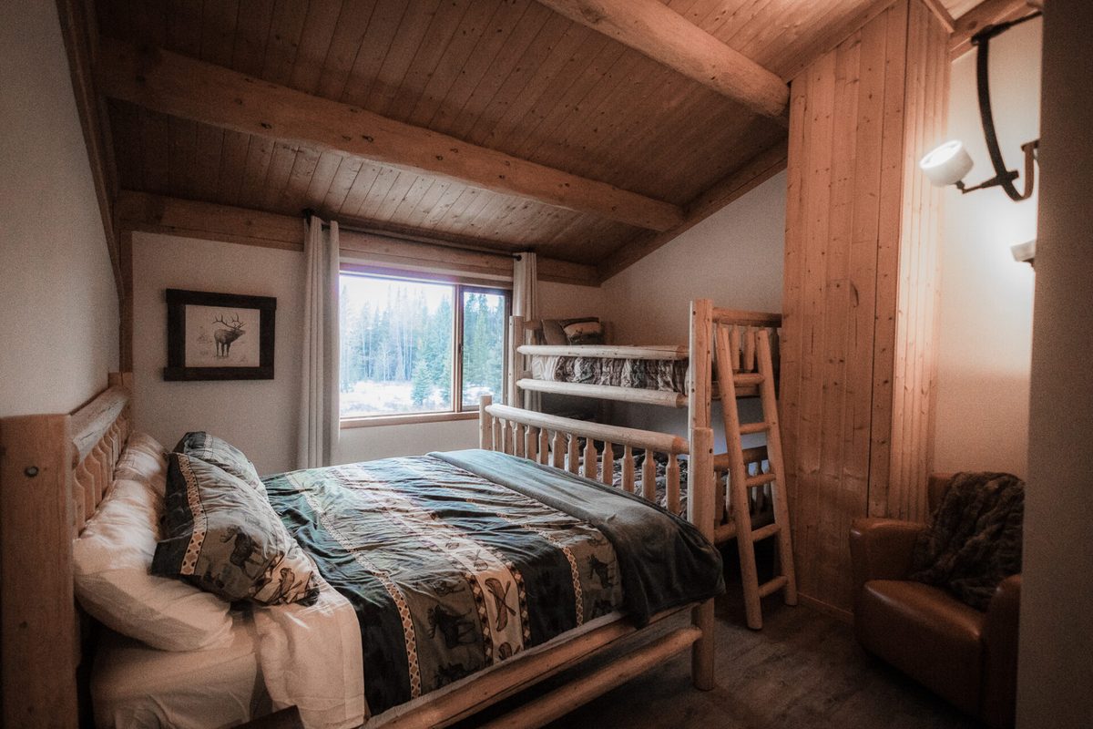 A King & Bunk suite with a private loft, log furniture and forest windows